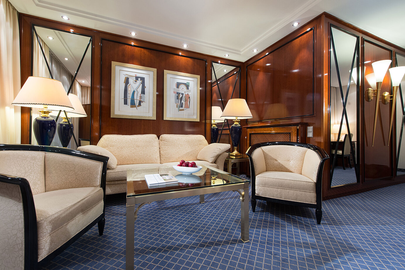Elegante area soggiorno di una suite al Maritim Hotel Fulda con arredi raffinati, tavolino in vetro e luce accogliente.