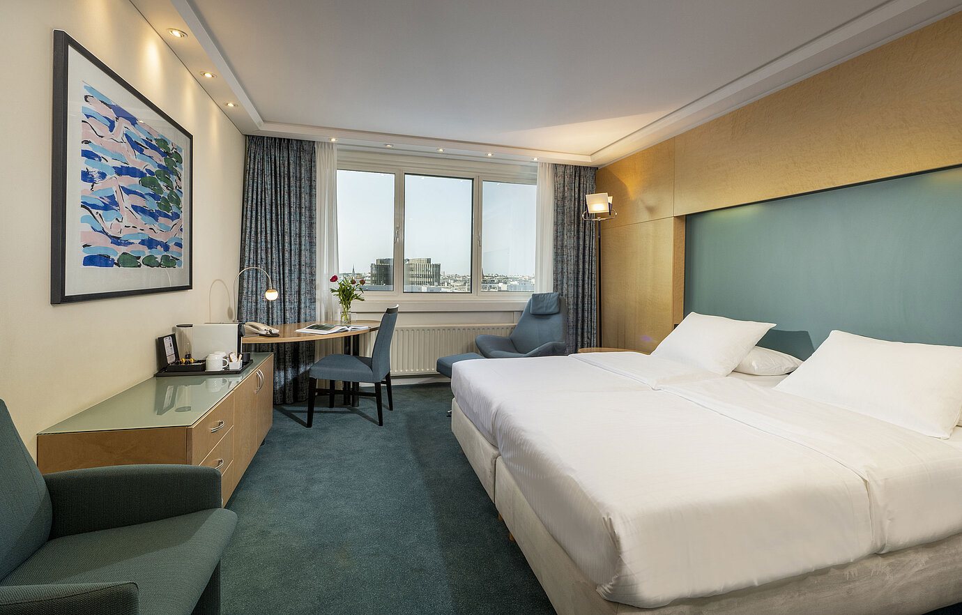 Modernly furnished Superior room at Maritim proArte Hotel Berlin with large bed, desk, artwork, and city view from the window