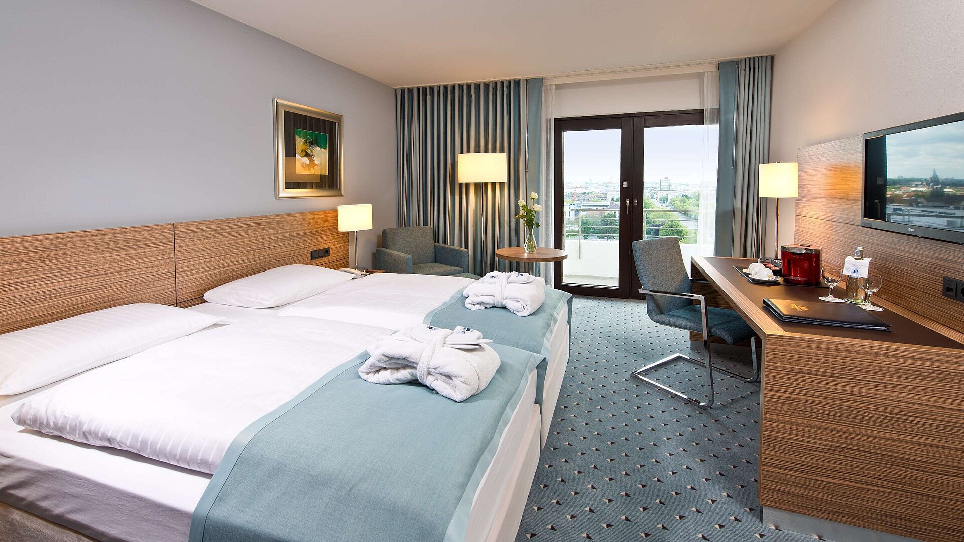 Superior room at Maritim Hotel Darmstadt featuring stylish design, desk, cozy seating area, and double bed with bathrobes.