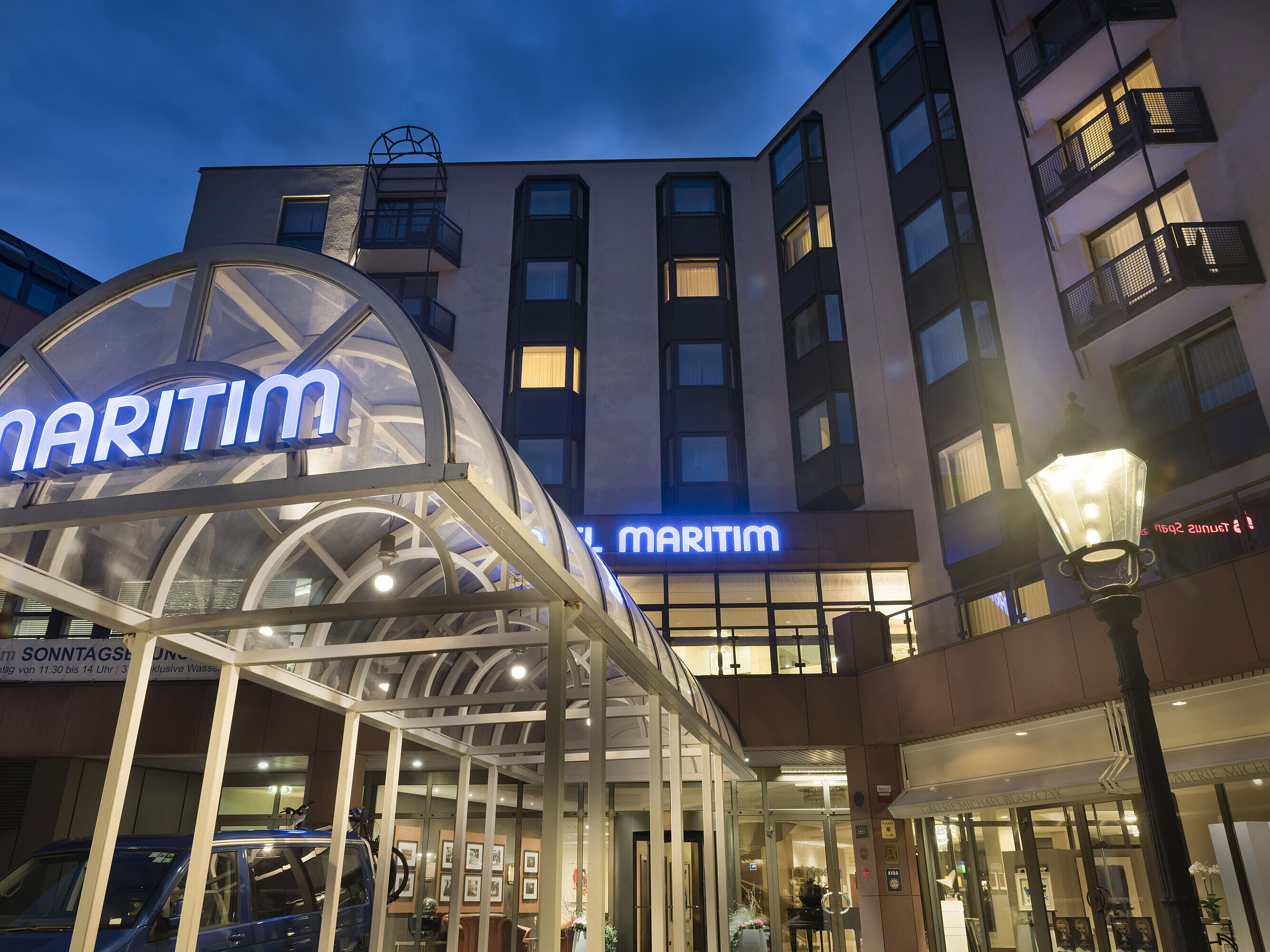 Vue détaillée de l'entrée éclairée de l'hôtel Maritim Bad Homburg de nuit.