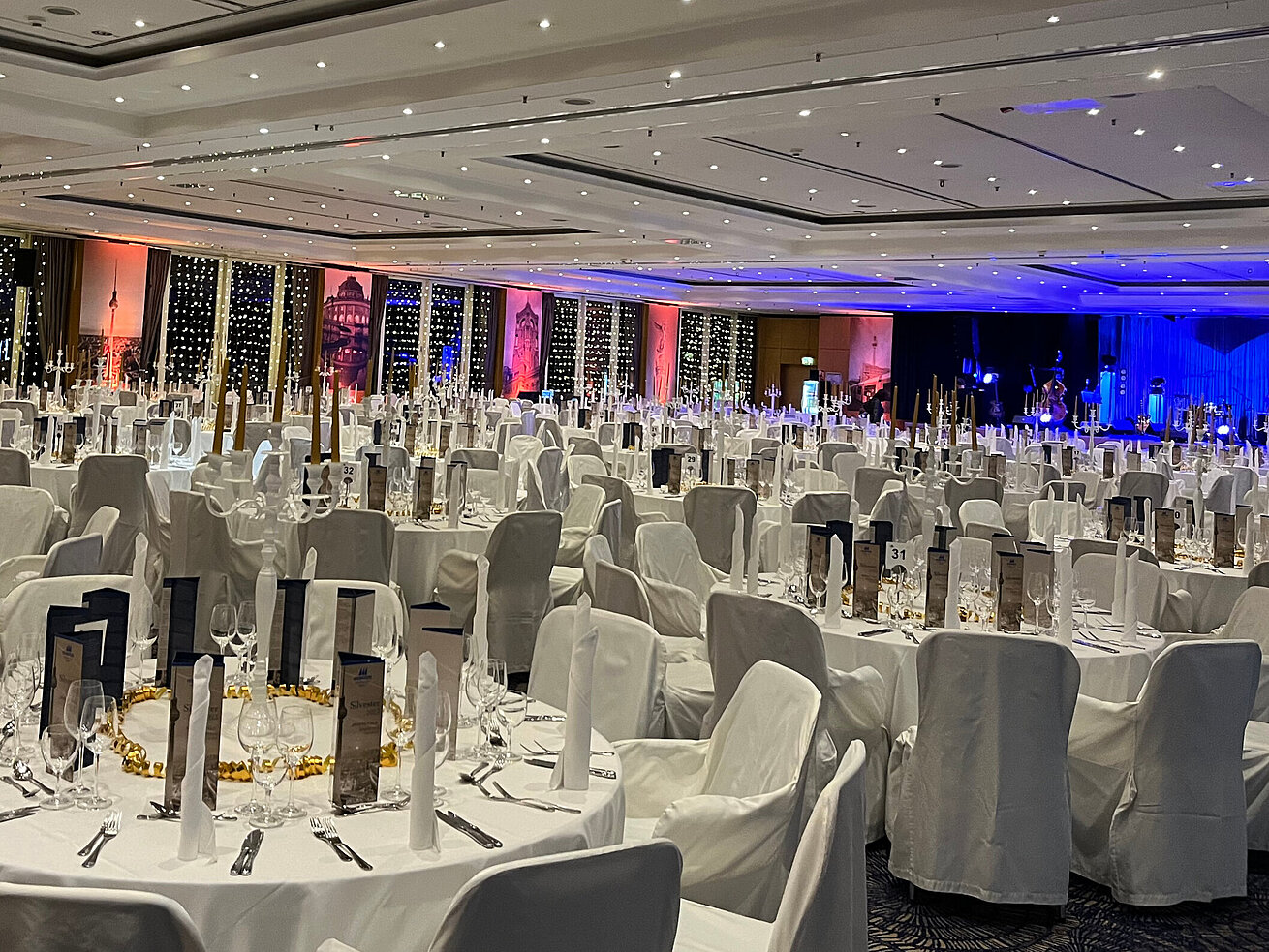 Elegantly set tables and a decorated event hall for a New Year's Eve celebration in Berlin.