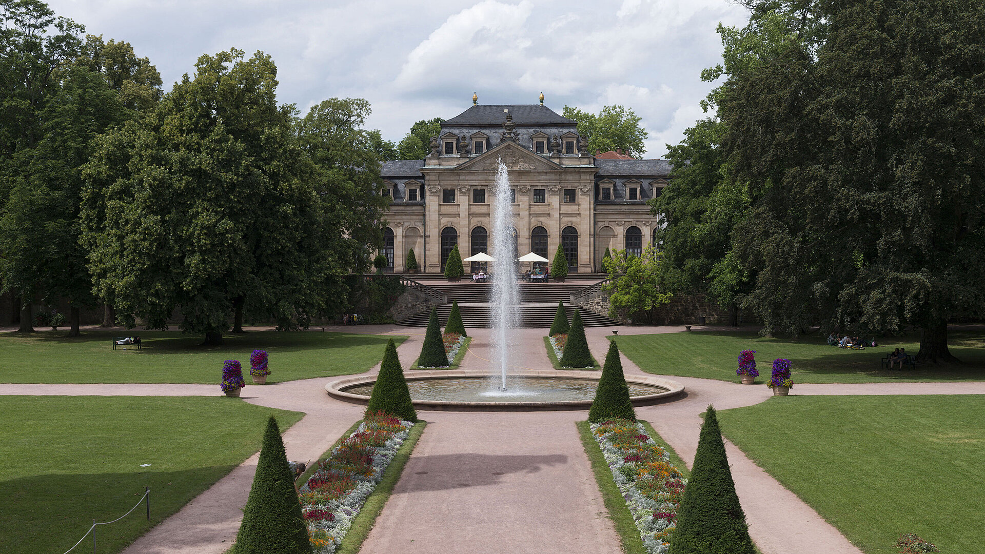 The baroque Orangerie Fulda with palace garden, fountain, and manicured flower beds in the foreground.