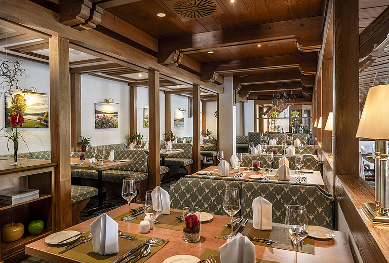 Restaurante acogedor con techo de madera y mesas elegantes en el Maritim Hotel Titisee
