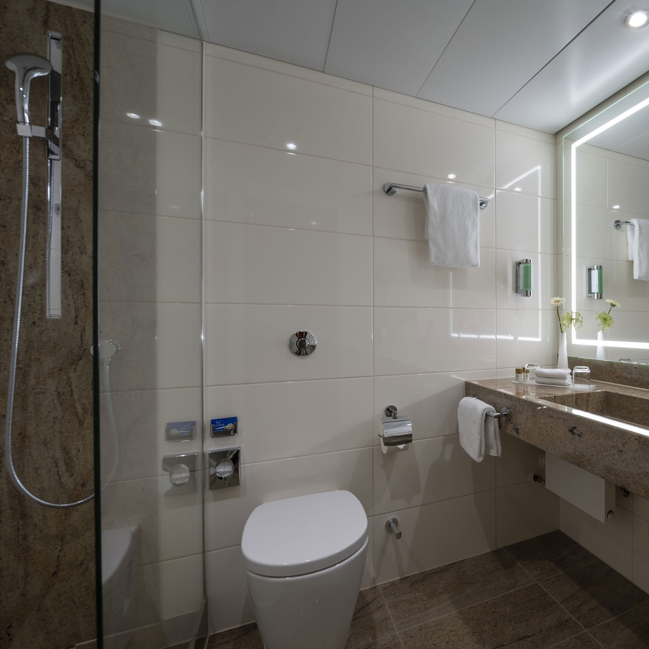 Comfort Bathroom Modern bathroom at the Maritim Hotel Bremen with luxurious fixtures, large illuminated mirror, and walk-in shower.