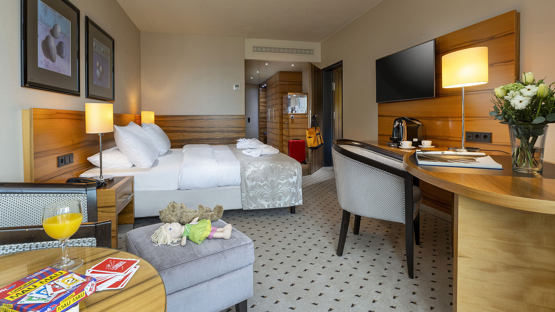 Comfort room at Maritim Hotel Bad Homburg with double bed, toys, teddy bear, and modern wood decor.