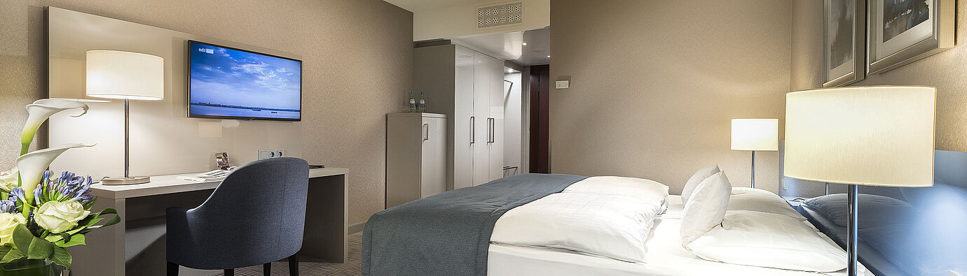 Habitación Superior en el Hotel Maritim Bonn con cama doble, escritorio, TV y decoración moderna. Confortable y elegante.