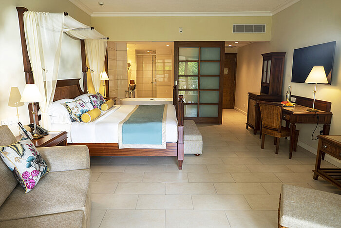 Deluxe plus room Spacious hotel room with double bed, desk and open bathroom area at Maritim Hotel