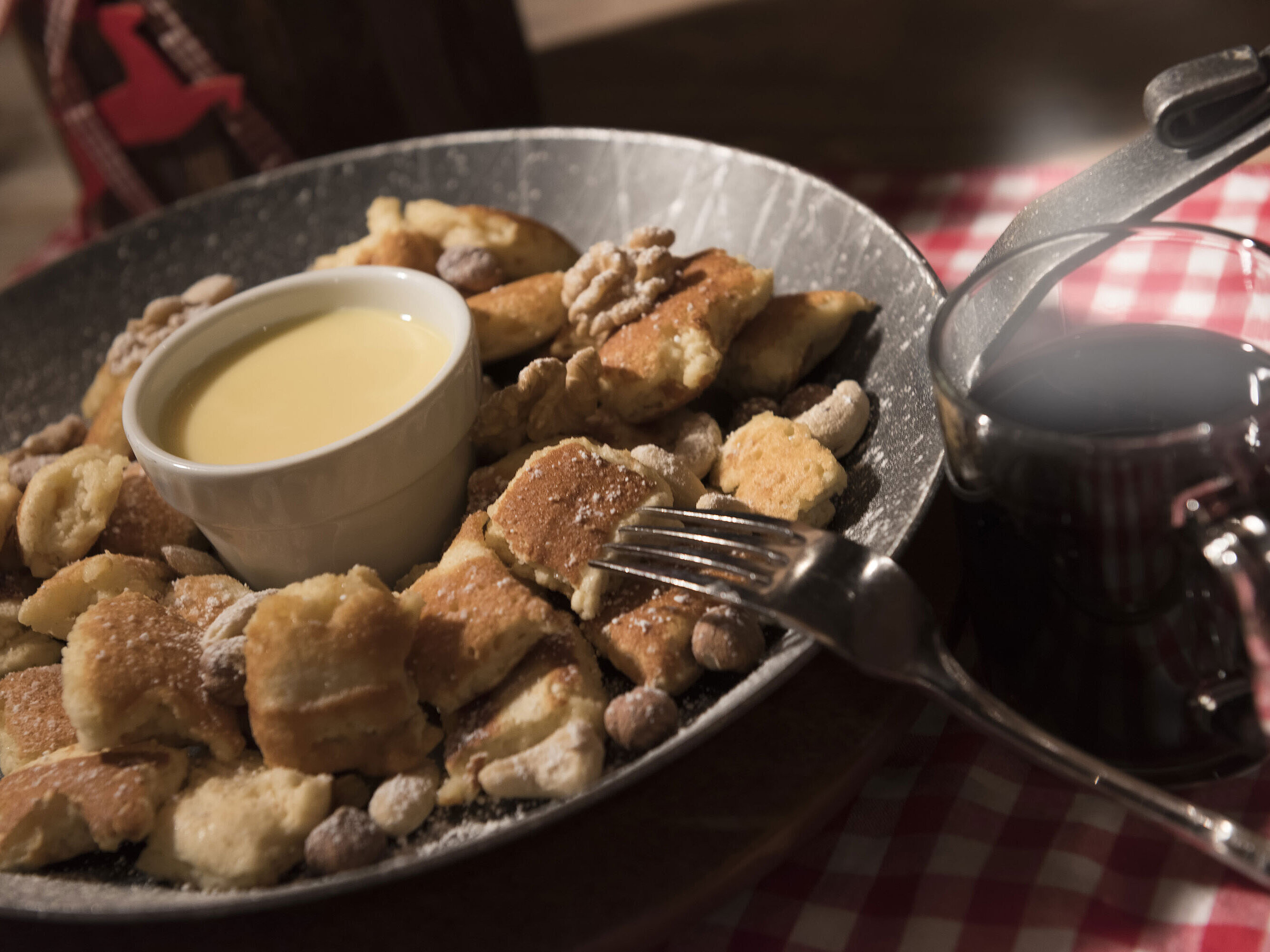 Fresh Kaiserschmarrn with nuts, icing sugar and vanilla sauce served with mulled wine at Maritim Alm