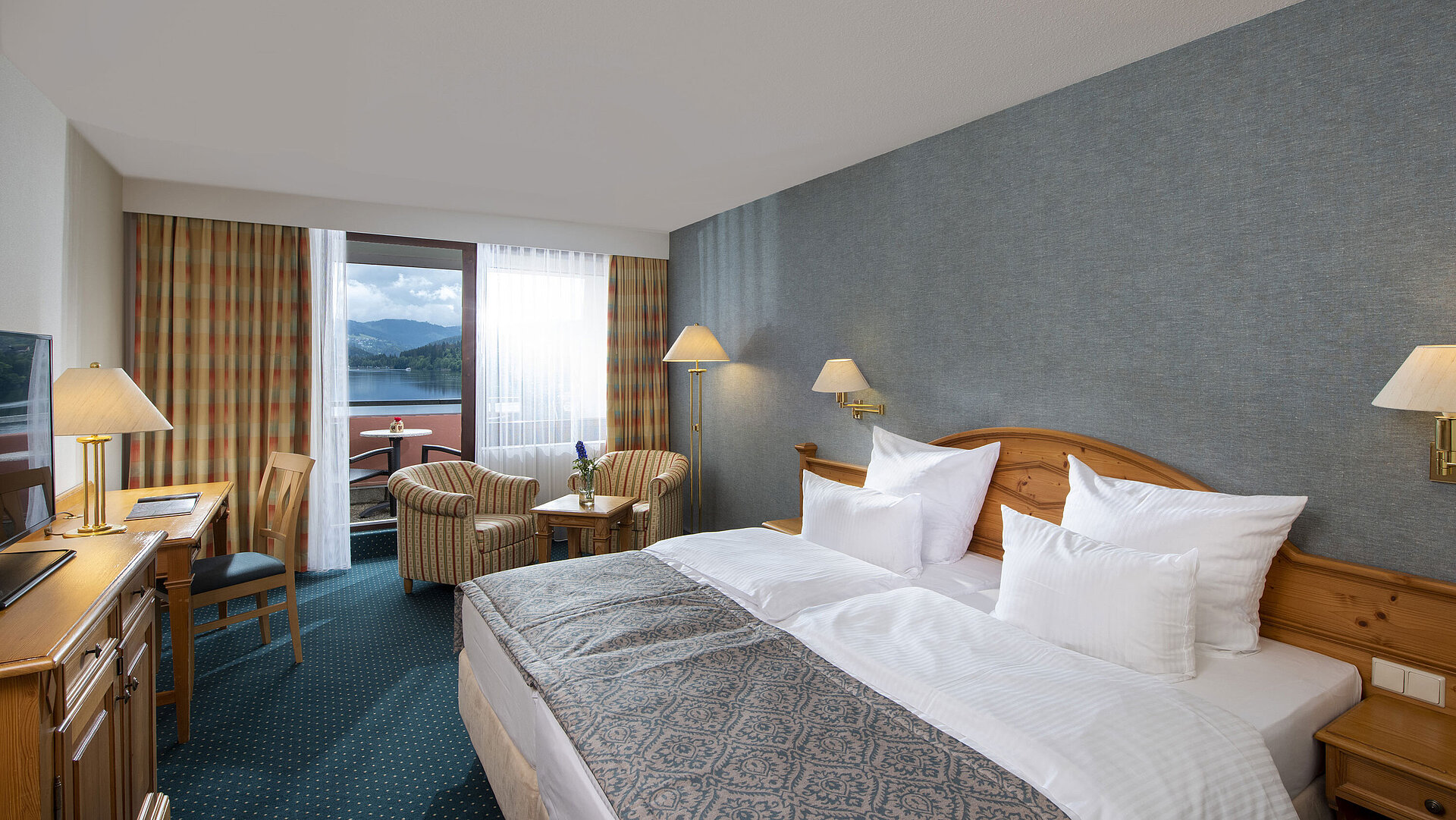 Amplia habitación en Maritim TitiseeHotel con sala y vista al lago