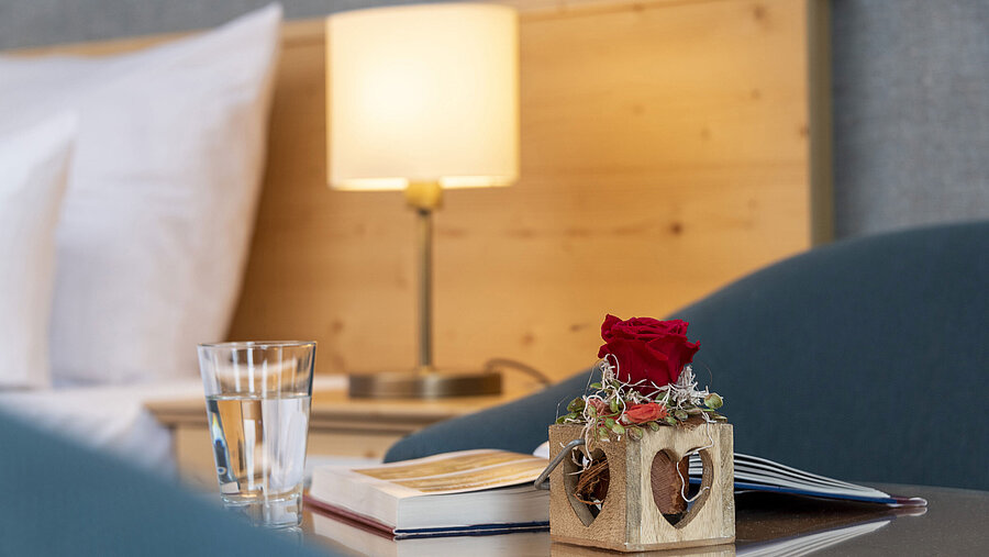 Rosa roja en jarrón de madera con corazón en habitación del Maritim TitiseeHotel