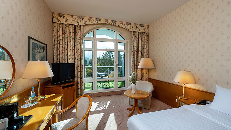 Habitación individual Superior con cama, escritorio, gran ventana, vista al balcón y decoración clásica.