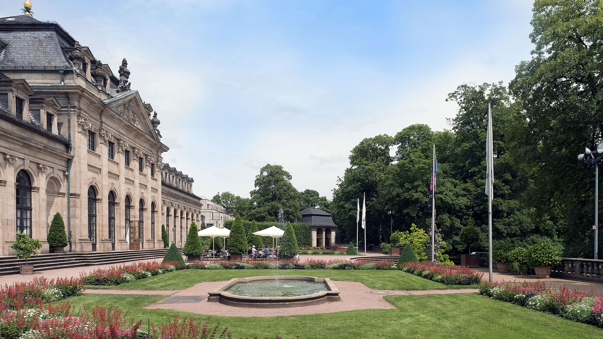 The baroque Orangerie Fulda with blooming garden, terrace, and historic pavilion in the background.