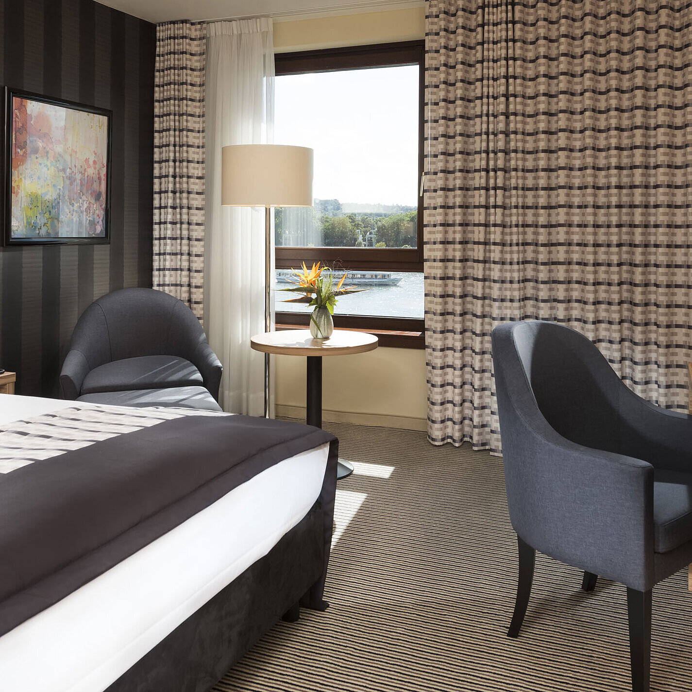 Camera doppia moderna del Maritim Hotel Königswinter con vista sul Reno e arredo elegante.
