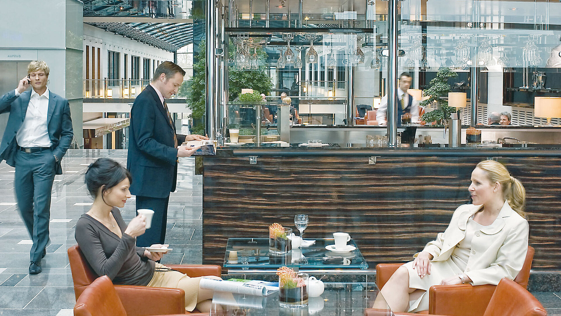 Bright lobby at Maritim Hotel Düsseldorf with seating, glass ceiling, and modern café area.