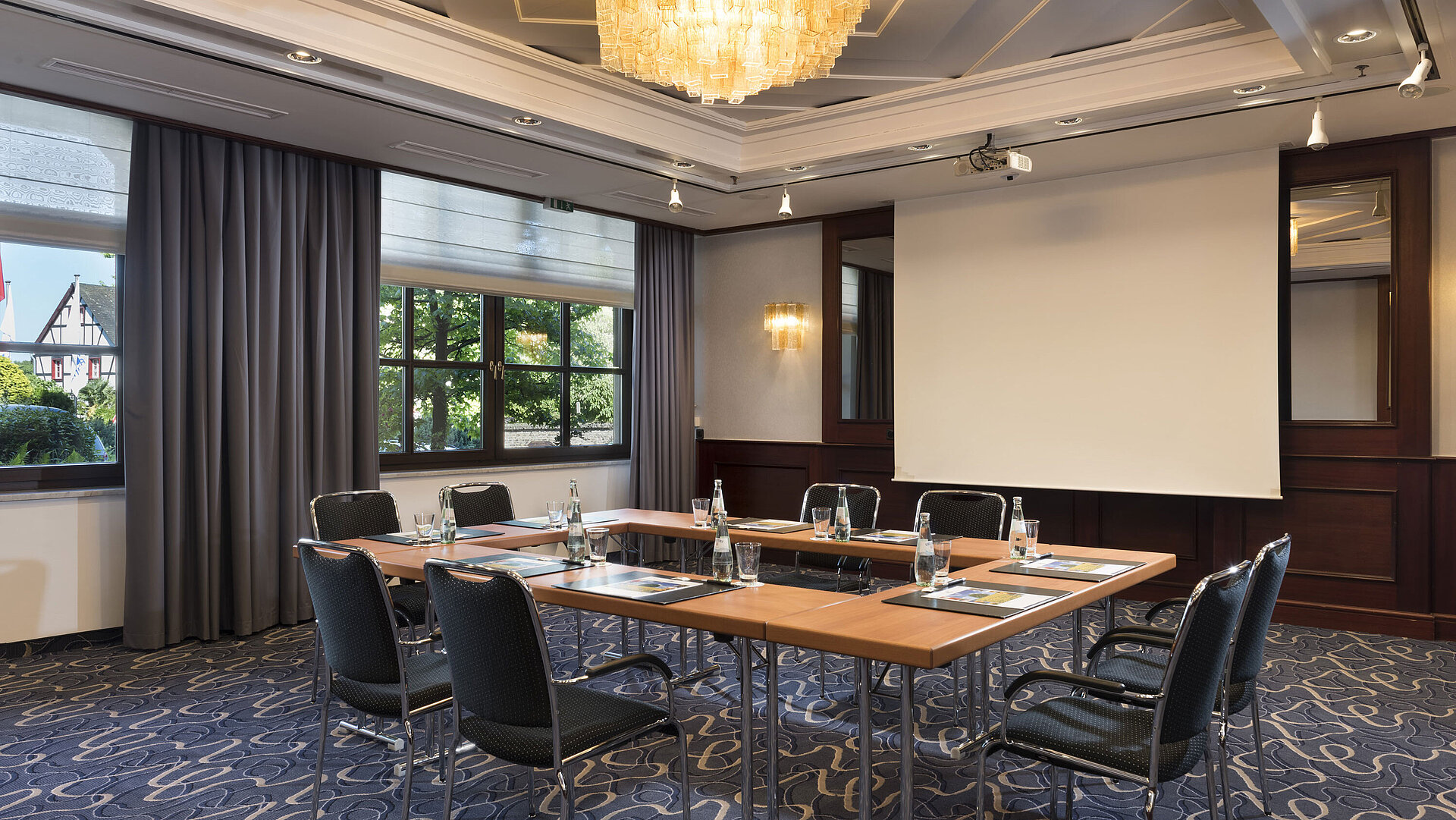 Salle de réunion lumineuse avec technologie moderne, grandes fenêtres et lustre élégant au Maritim Hotel Königswinter.