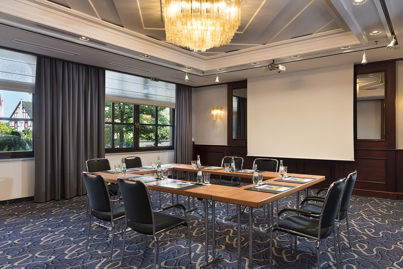 Salle de réunion lumineuse avec technologie moderne, grandes fenêtres et lustre élégant au Maritim Hotel Königswinter.