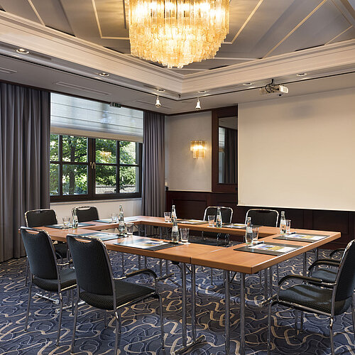 Salle de réunion lumineuse avec technologie moderne, grandes fenêtres et lustre élégant au Maritim Hotel Königswinter.