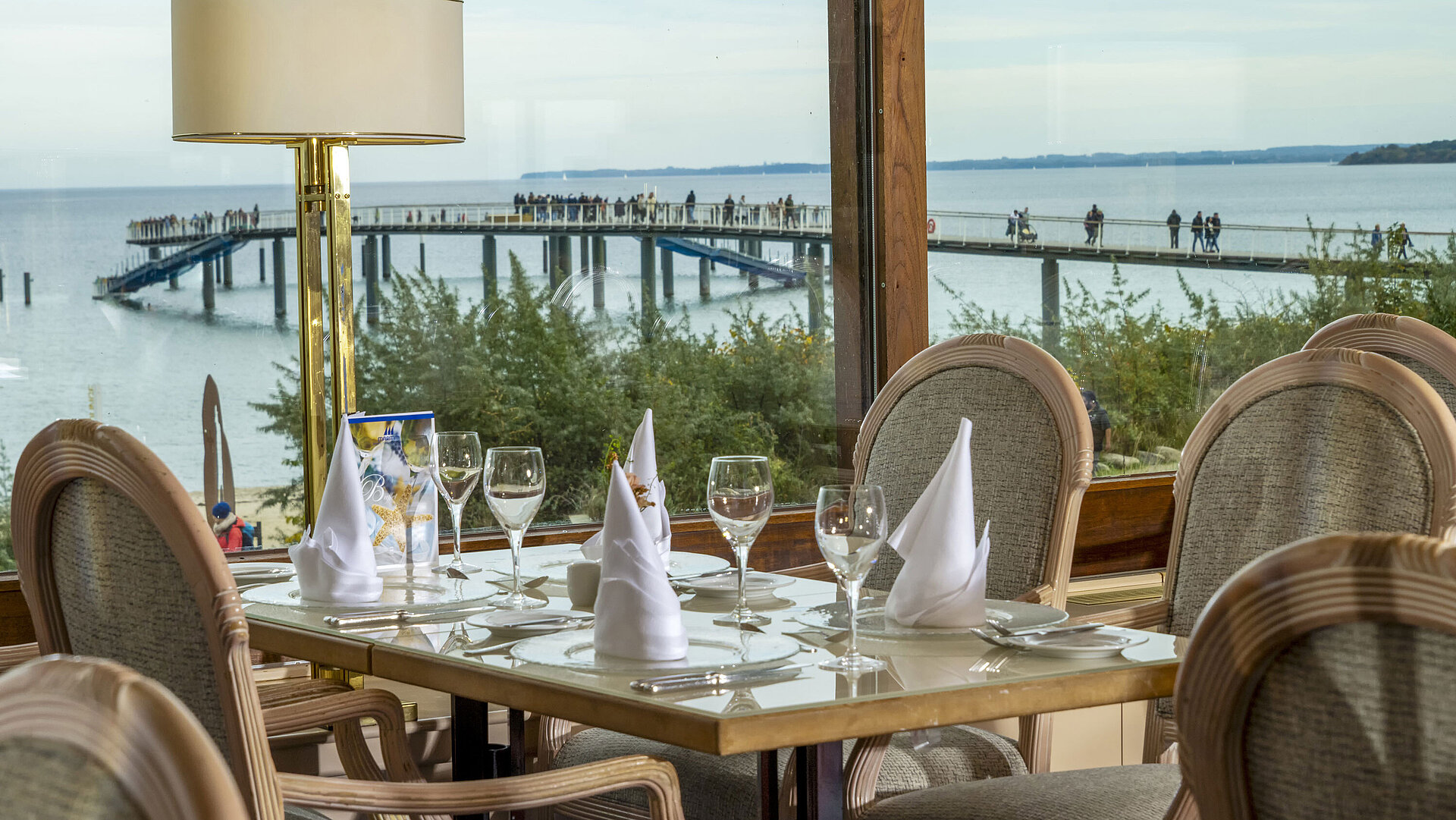Tavolo elegante con vista sul Mar Baltico e molo, Hotel Maritim Timmendorfer Strand.Tavolo elegante con vista sul Mar Baltico e molo, Hotel Maritim Timmendorfer Strand.