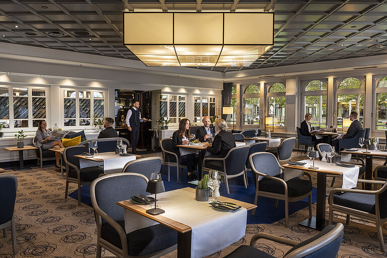  Restaurante elegante donde los huéspedes cenan y se relajan. Mobiliario moderno y grandes ventanales con vistas.
