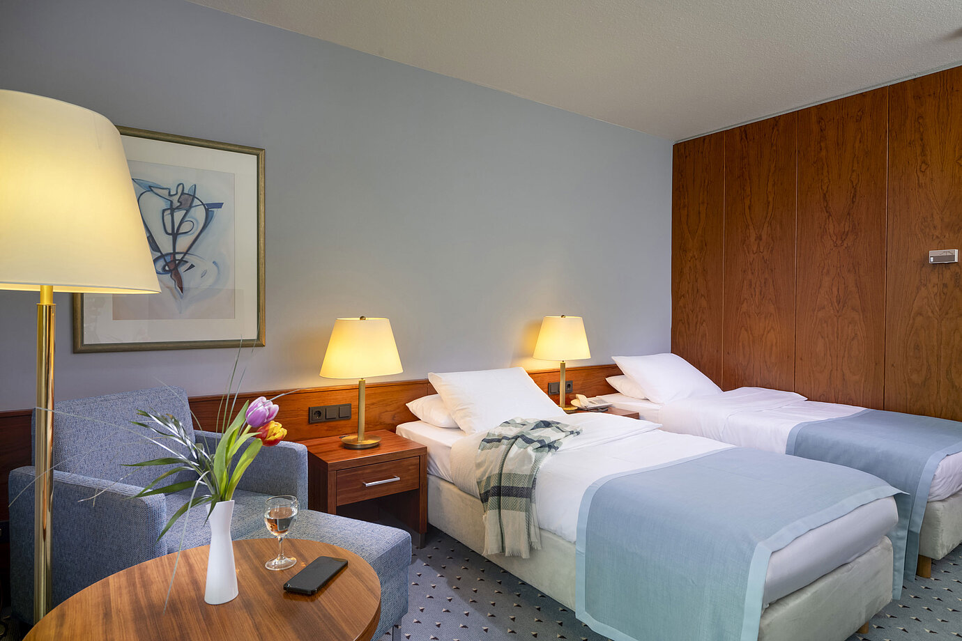 Habitación twin confort en el Hotel Maritim Darmstadt con dos camas individuales, área de estar acogedora y diseño elegante.