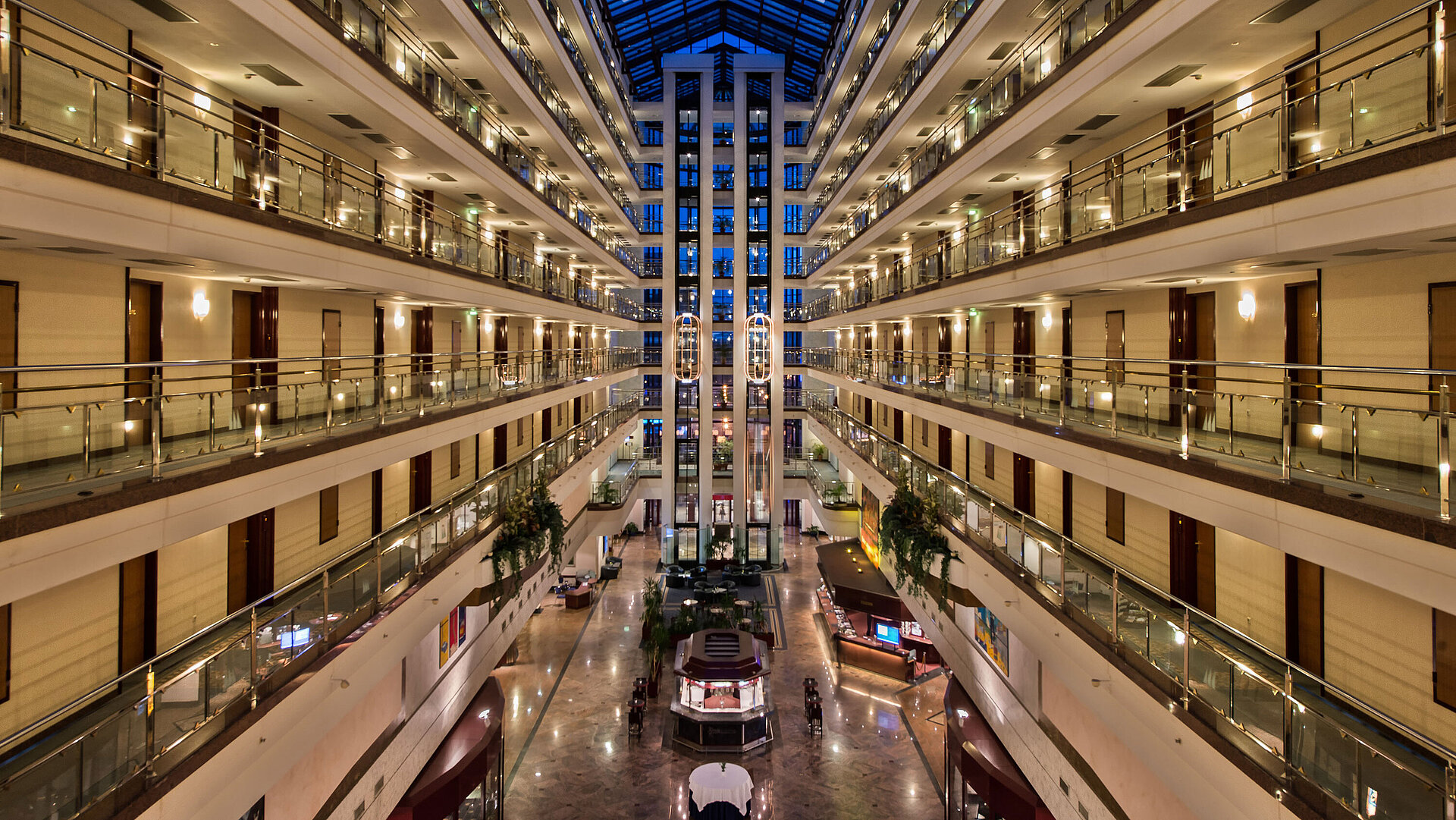 The spacious, bright lobby of Maritim Hotel with illuminated floors and modern architecture at night.
