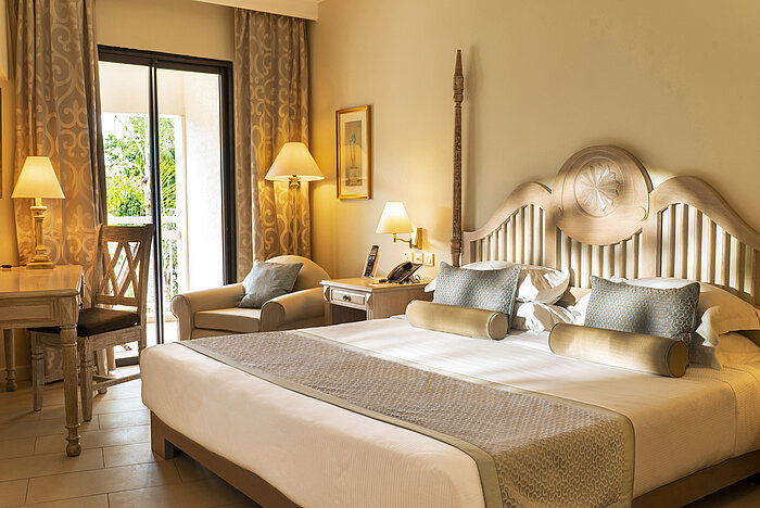 Suite Suite with four-poster bed, seating area and open bathroom concept at Maritim Hotel