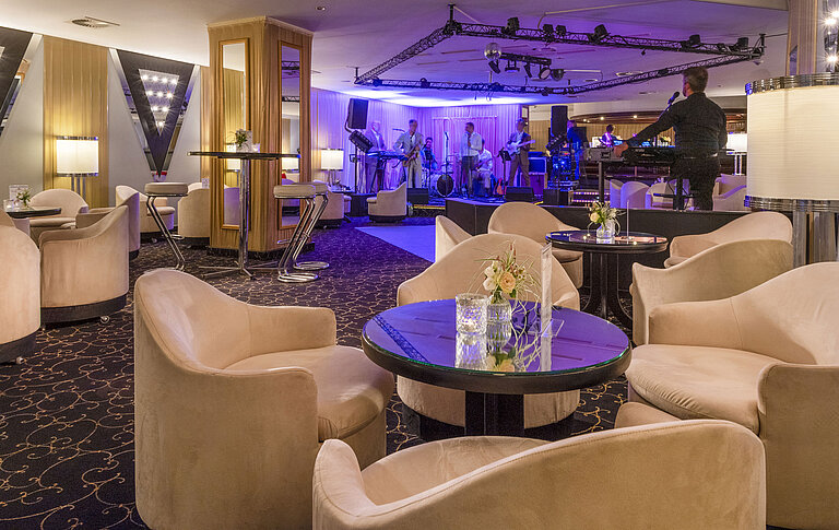 Espace bar élégant avec orchestre live, éclairage d'ambiance et sièges confortables pour les invités.