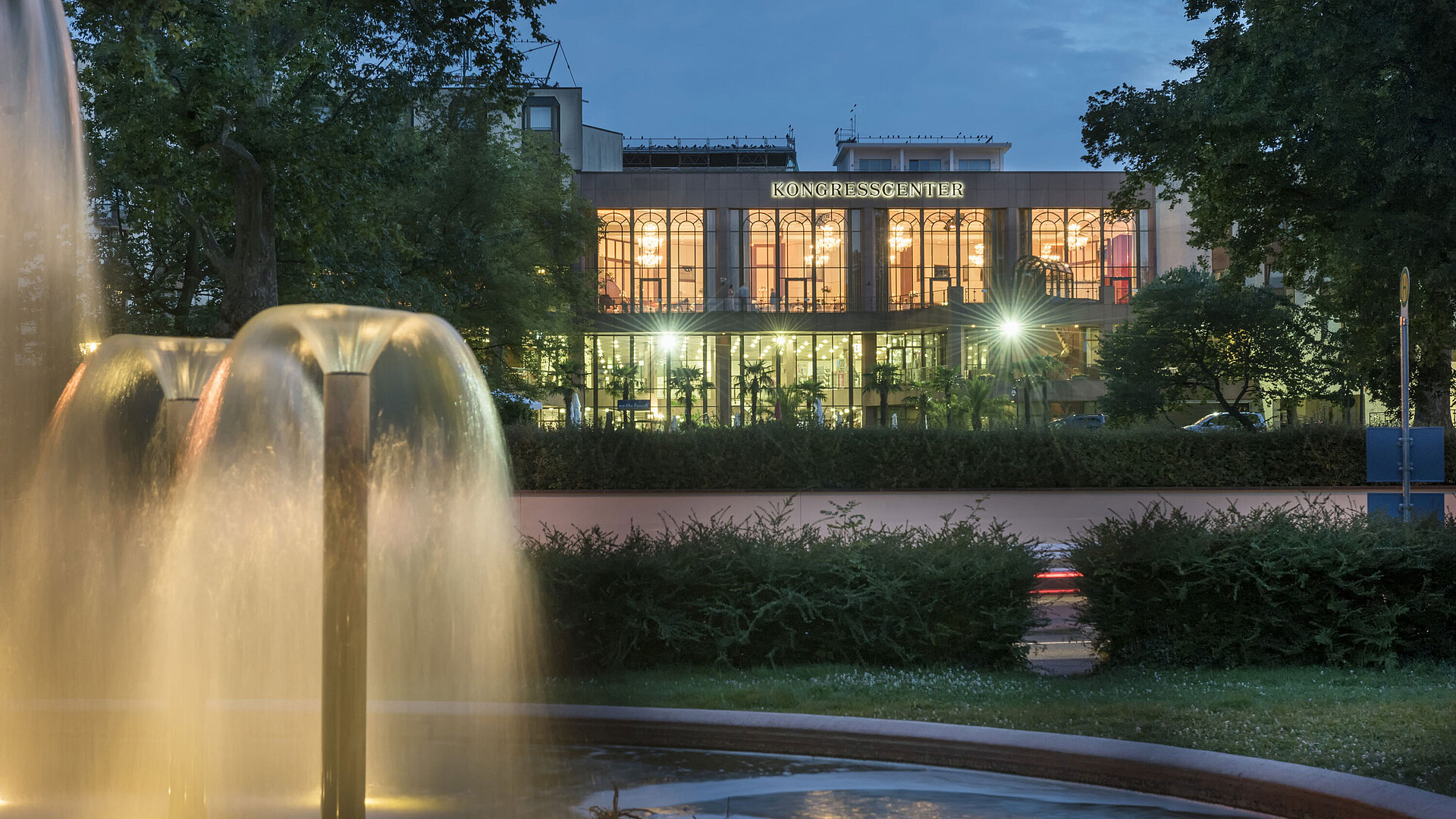 Atmospheric evening view of the congress center at Maritim Hotel Bad Homburg with illuminated fountain.