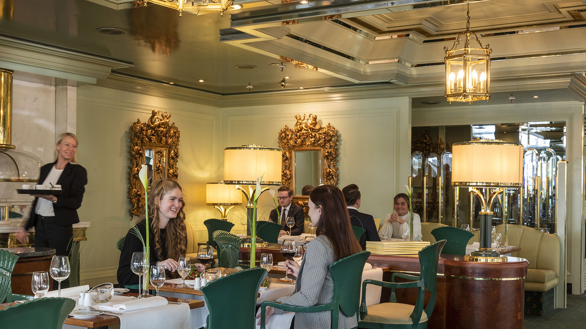 La Galerie Restaurant Guests enjoying their meal in the "La Galerie" restaurant at Maritim Hotel Cologne, surrounded by stylish mirrors and lamps.