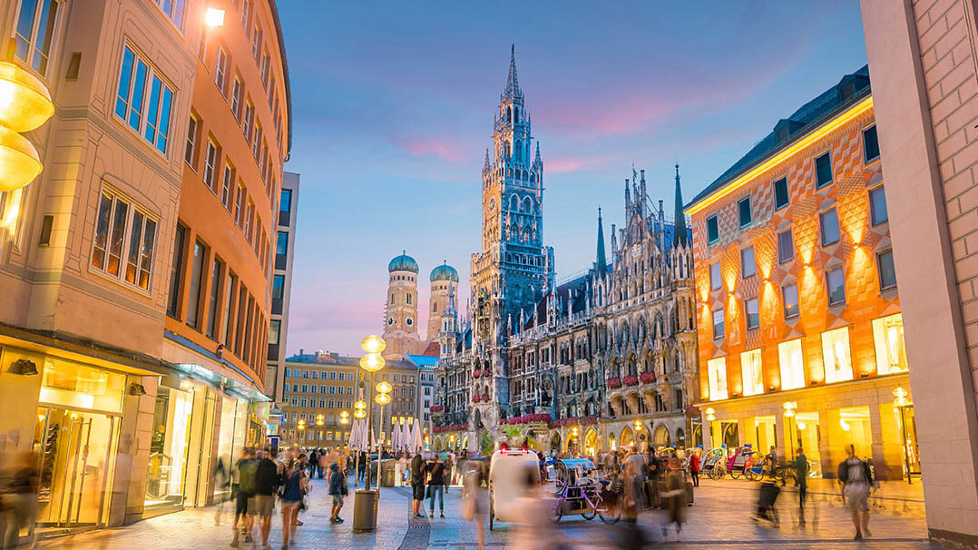 Marienplatz in Munich with New Town Hall, illuminated buildings and lively city centre in the evening