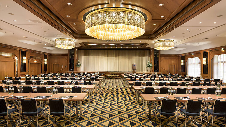 Sala de conferencias elegante con escenario, lámparas y asientos modernos en Maritim Hotel Königswinter.