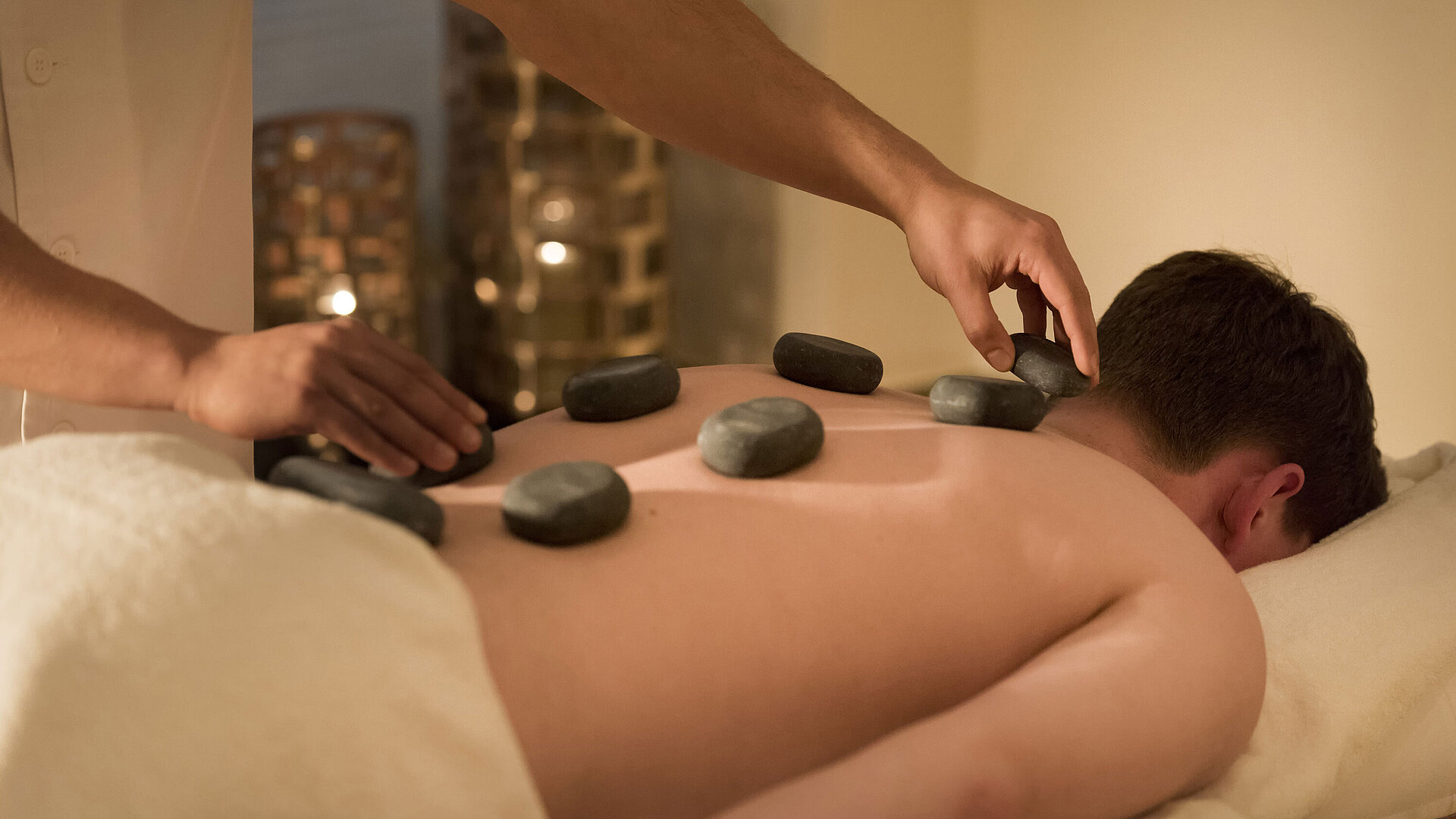 Massaggio con pietre calde per un relax profondo al centro benessere del Maritim Seehotel Timmendorfer Strand.