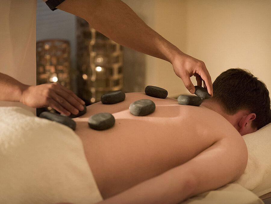 Massaggio con pietre calde per un relax profondo al centro benessere del Maritim Seehotel Timmendorfer Strand.