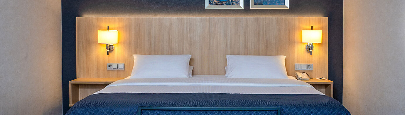 Double bed in the Superior Family room at Maritim Hotel Würzburg with modern design and cosy lighting
