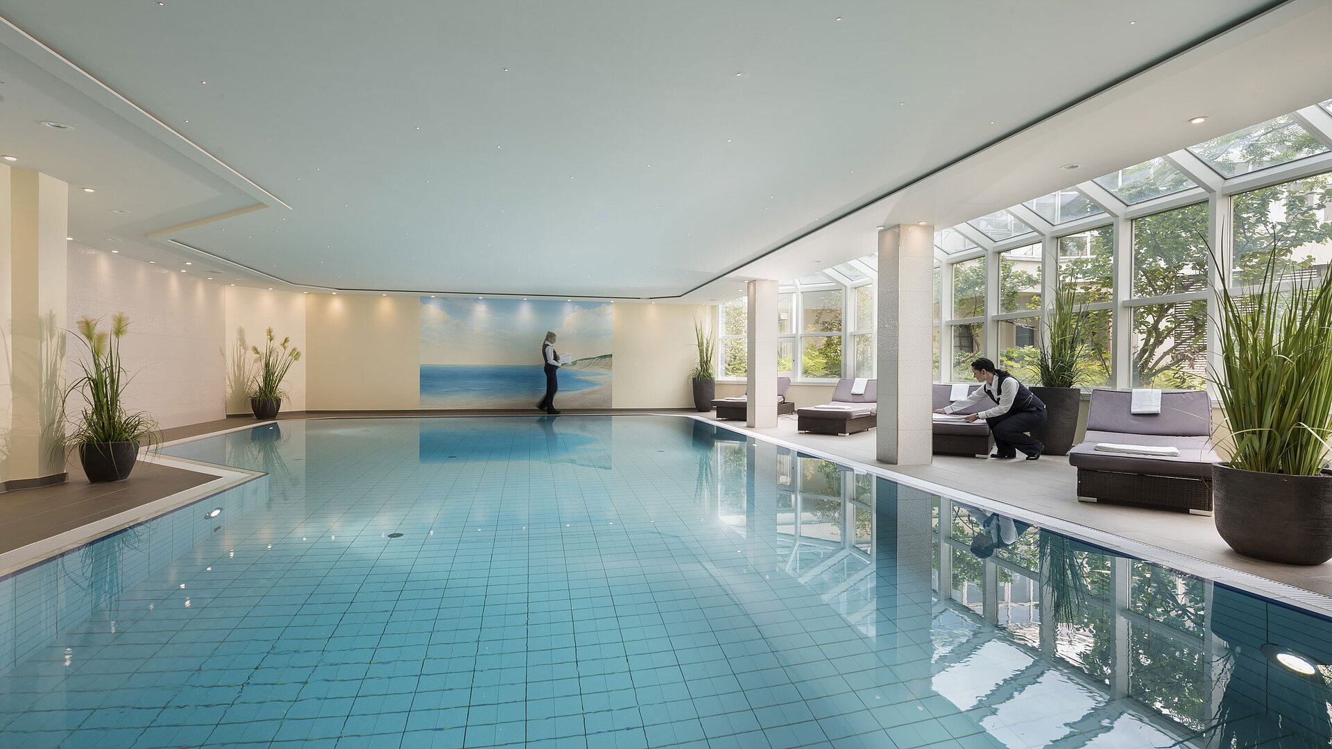 Gran piscina cubierta en el Maritim Hotel Würzburg con ventanales y servicio atento.