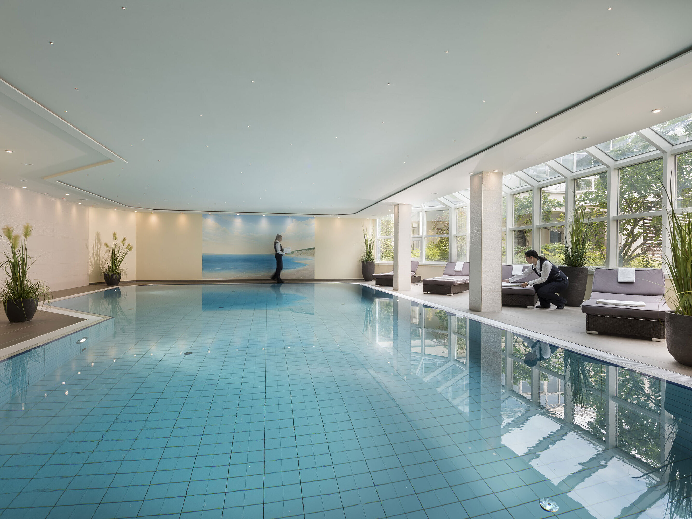 Gran piscina cubierta en el Maritim Hotel Würzburg con ventanales y servicio atento.