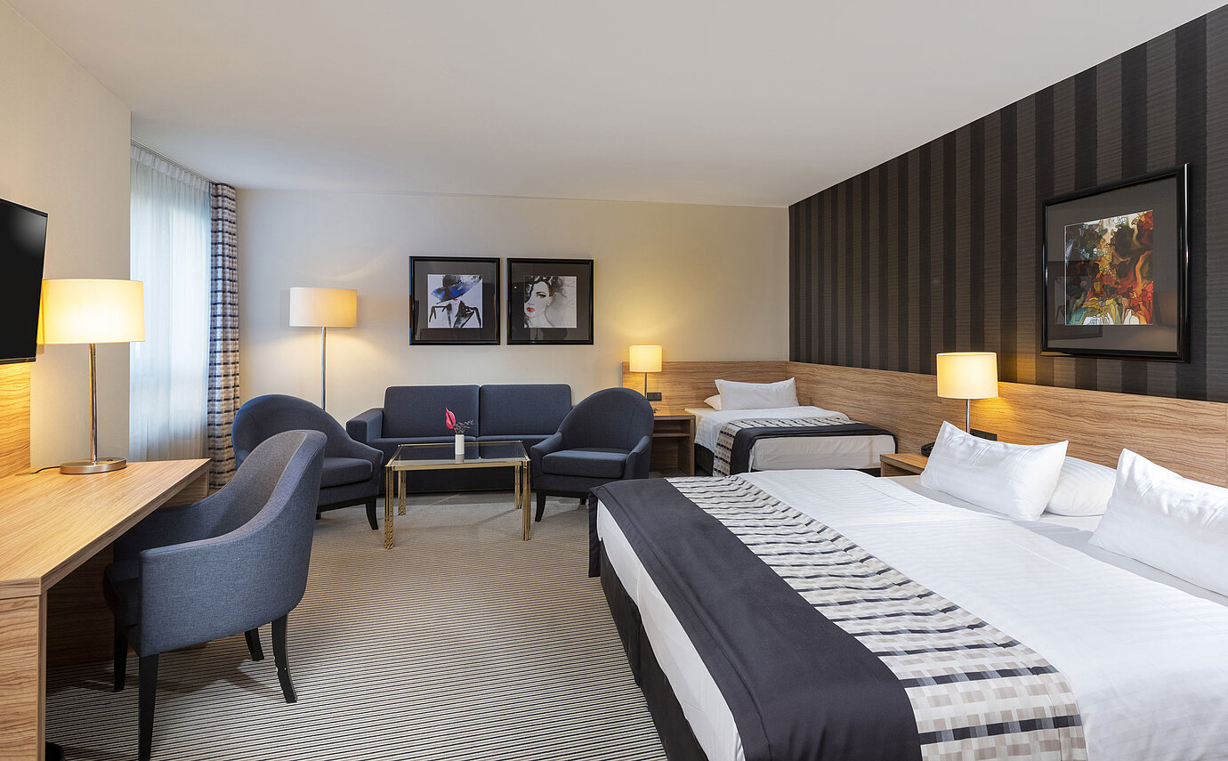 Habitación familiar cómoda con diseño elegante y zona de estar acogedora en el Maritim Hotel Königswinter.