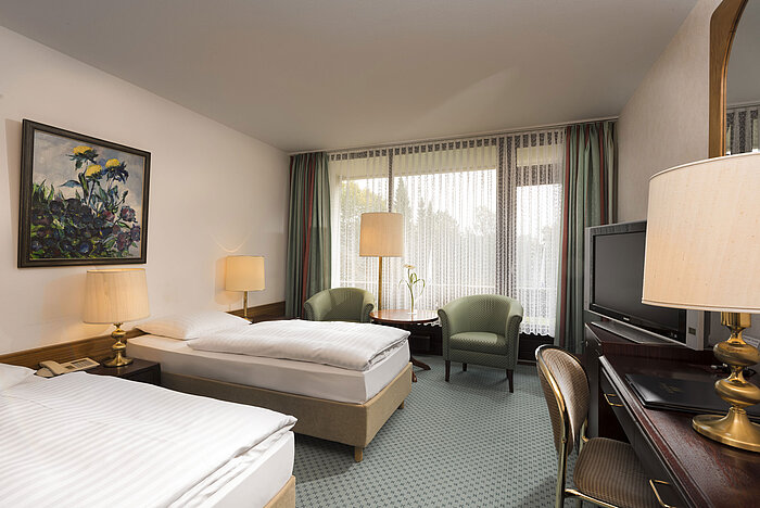 Due letti, poltrone e balcone al Maritim Hotel Bad Salzuflen