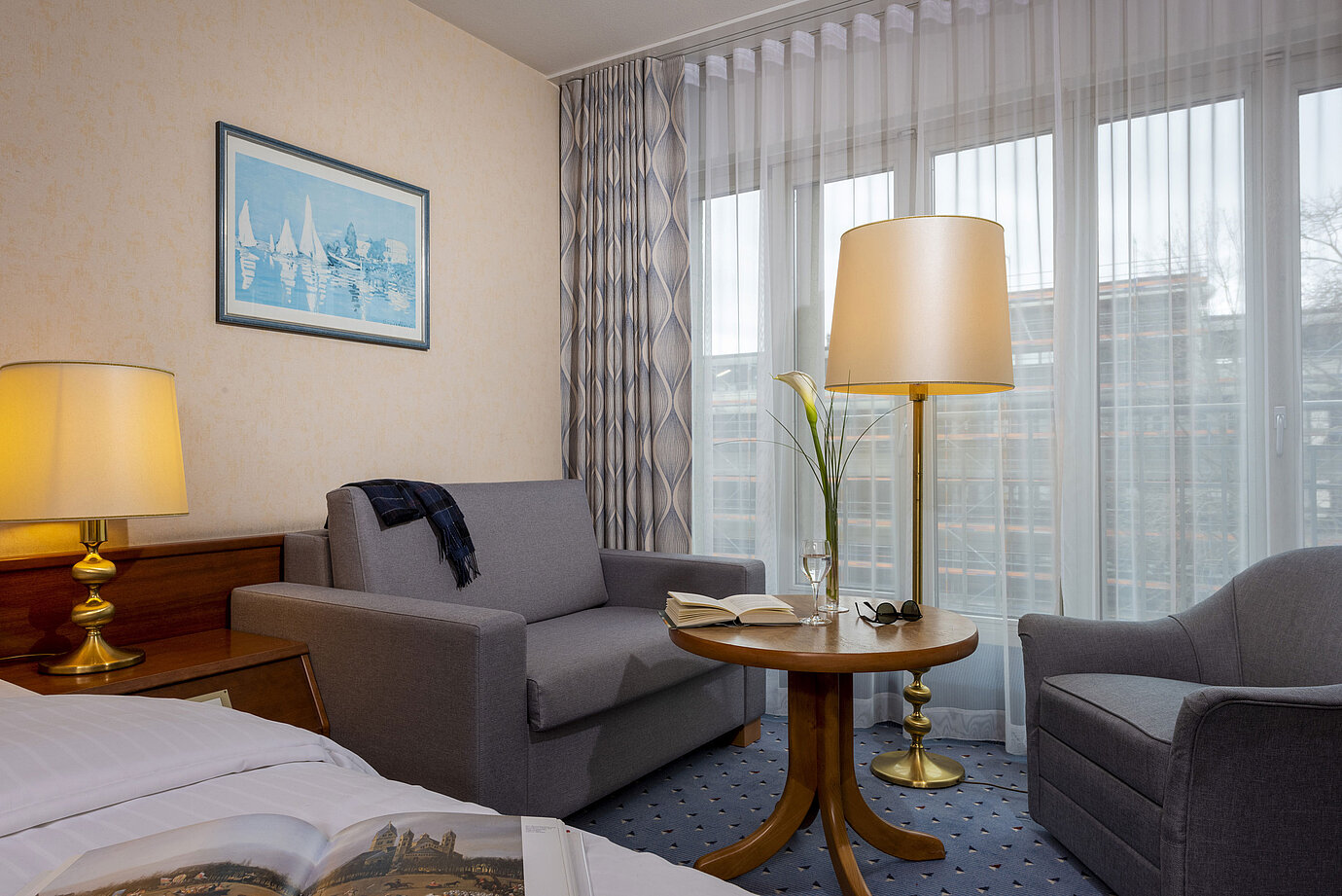 Comfort room at the Maritim Hotel Köln, with a cozy sitting area, reading table and modern furnishings.