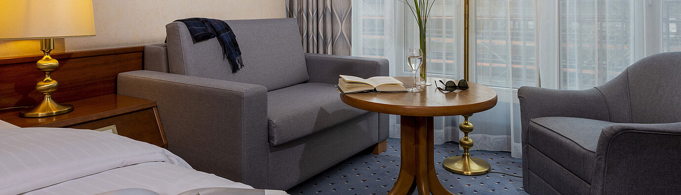 Comfort room at the Maritim Hotel Köln, with a cozy sitting area, reading table and modern furnishings.