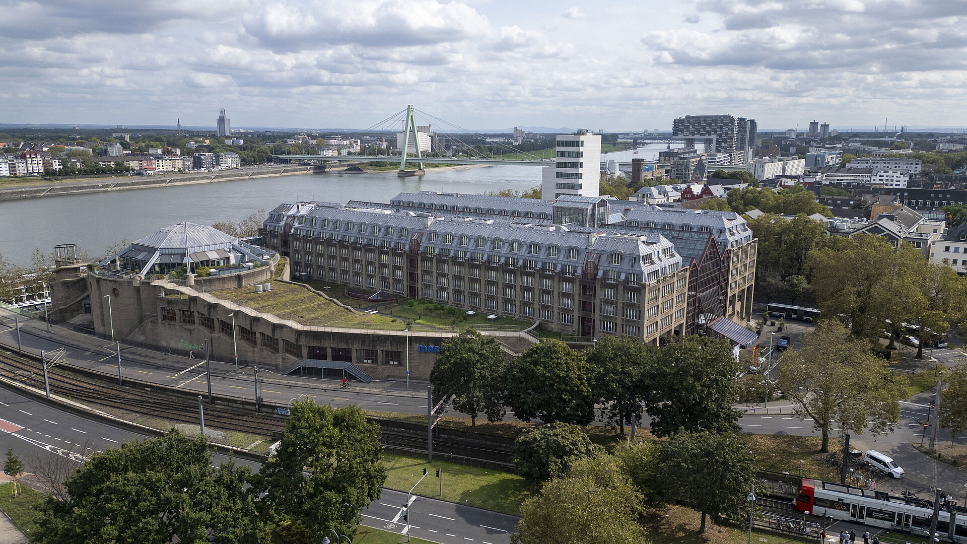 Aerial view of the Maritim Hotel Cologne, featuring the Rhine River, Severins Bridge, and surrounding buildings.