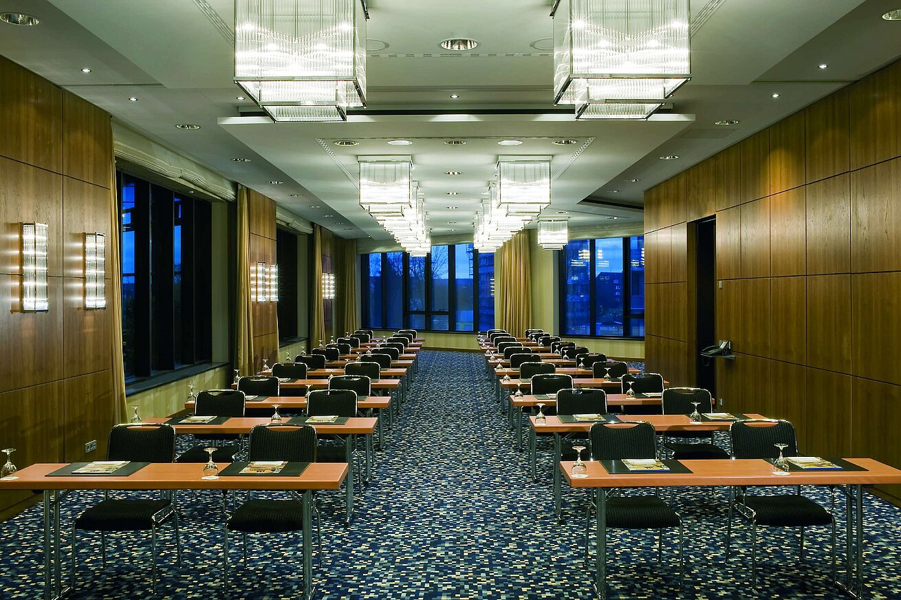 Sala de conferencias moderna en el Maritim Hotel Düsseldorf con asientos en fila e iluminación elegante para reuniones.