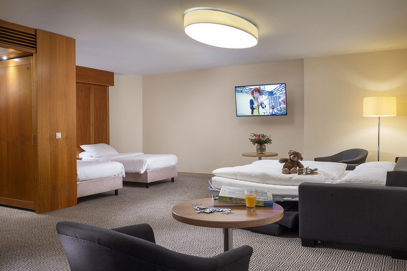 Large family room with TV, sofa bed, toys and puzzle at the Maritim Hotel Stuttgart