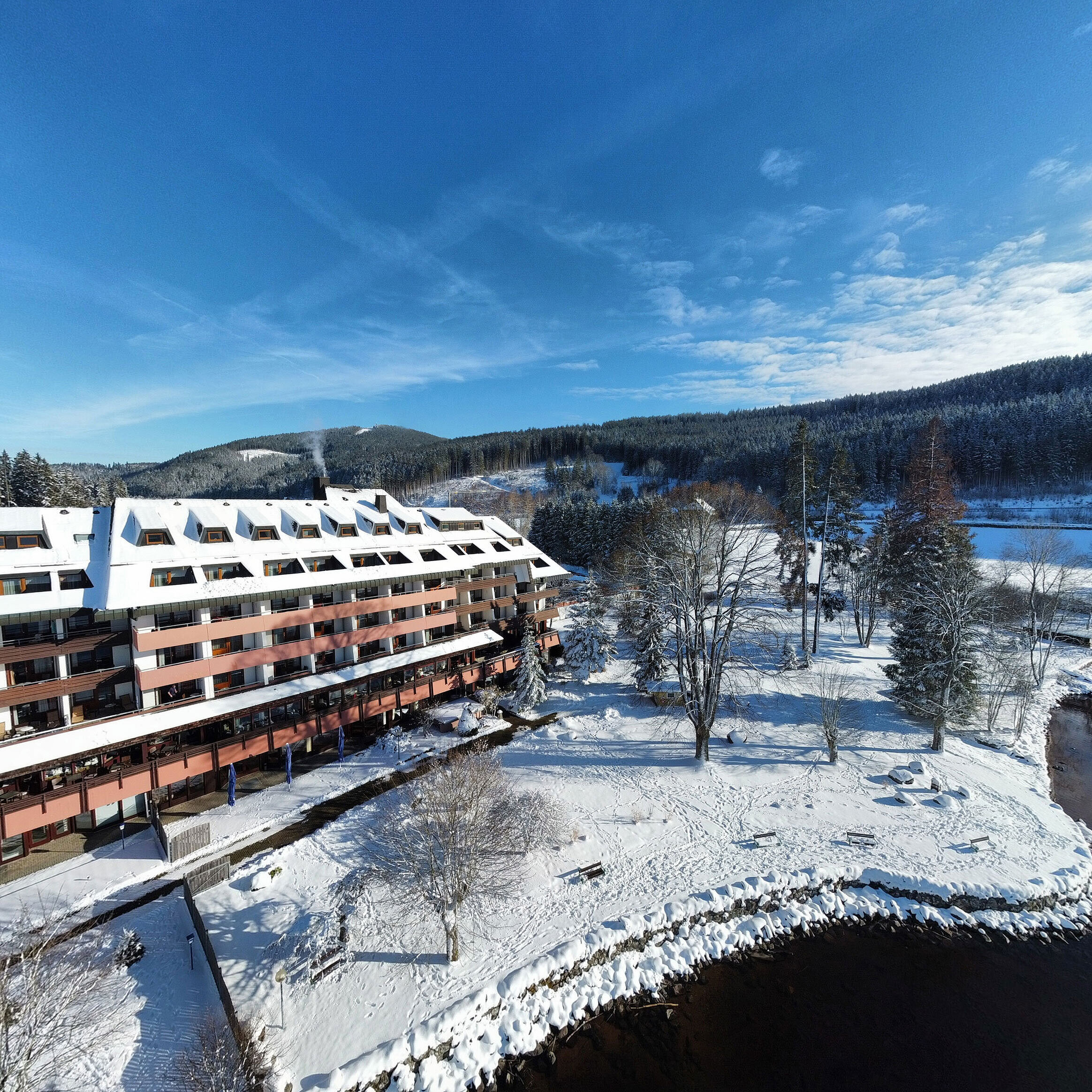 Maritim Hotel Titisee in winter with snow-covered garden and hotel by the lakeside