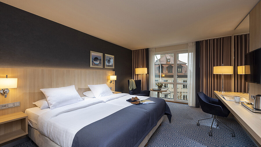 Elegante Habitación Superior en el Maritim Hotel Würzburg con cama doble grande y vistas a tejados históricos
