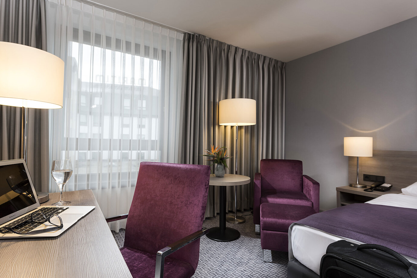 Habitación individual elegante del Maritim Hotel Königswinter con escritorio, sillón y diseño moderno.