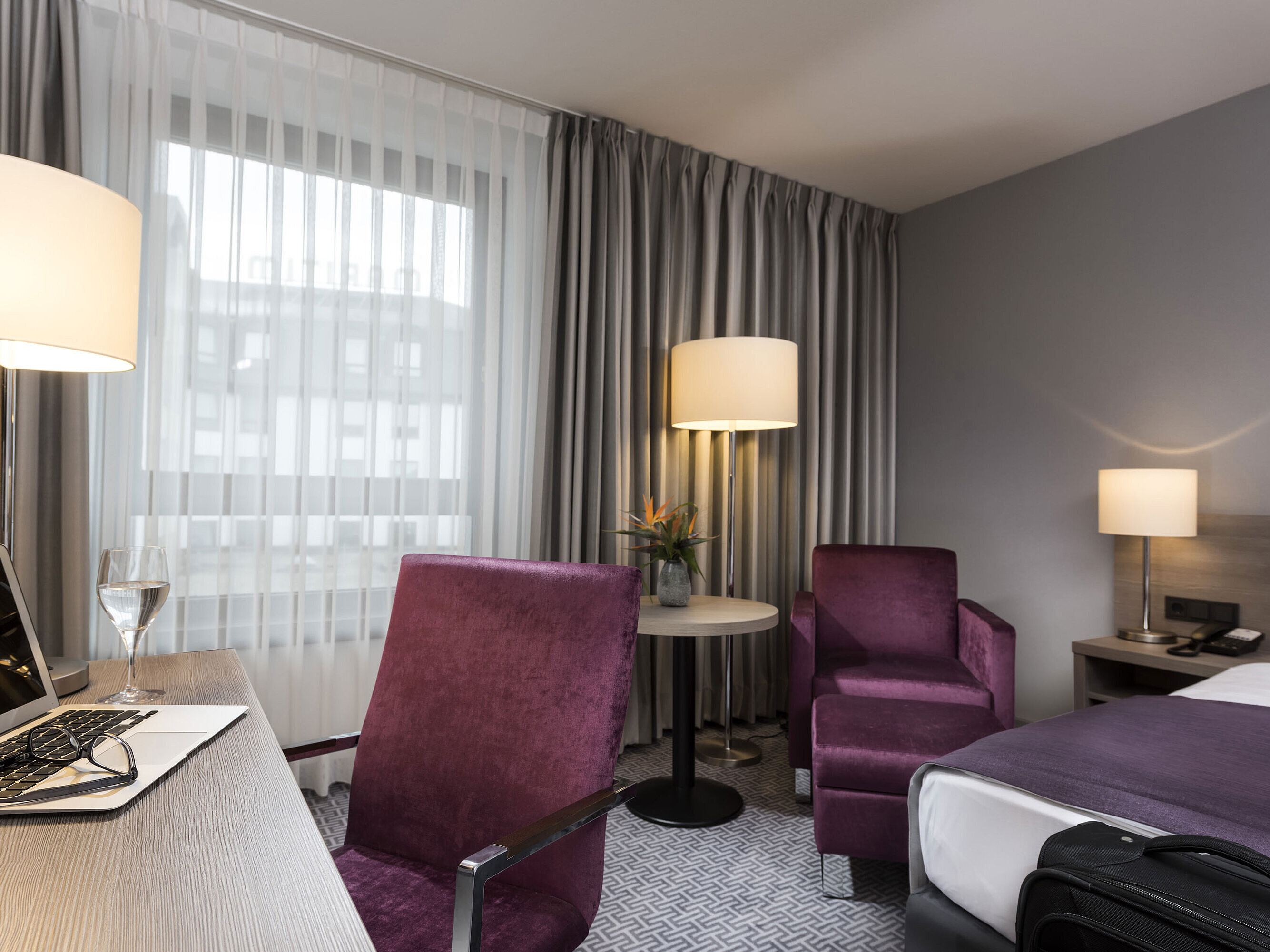 Habitación individual elegante del Maritim Hotel Königswinter con escritorio, sillón y diseño moderno.