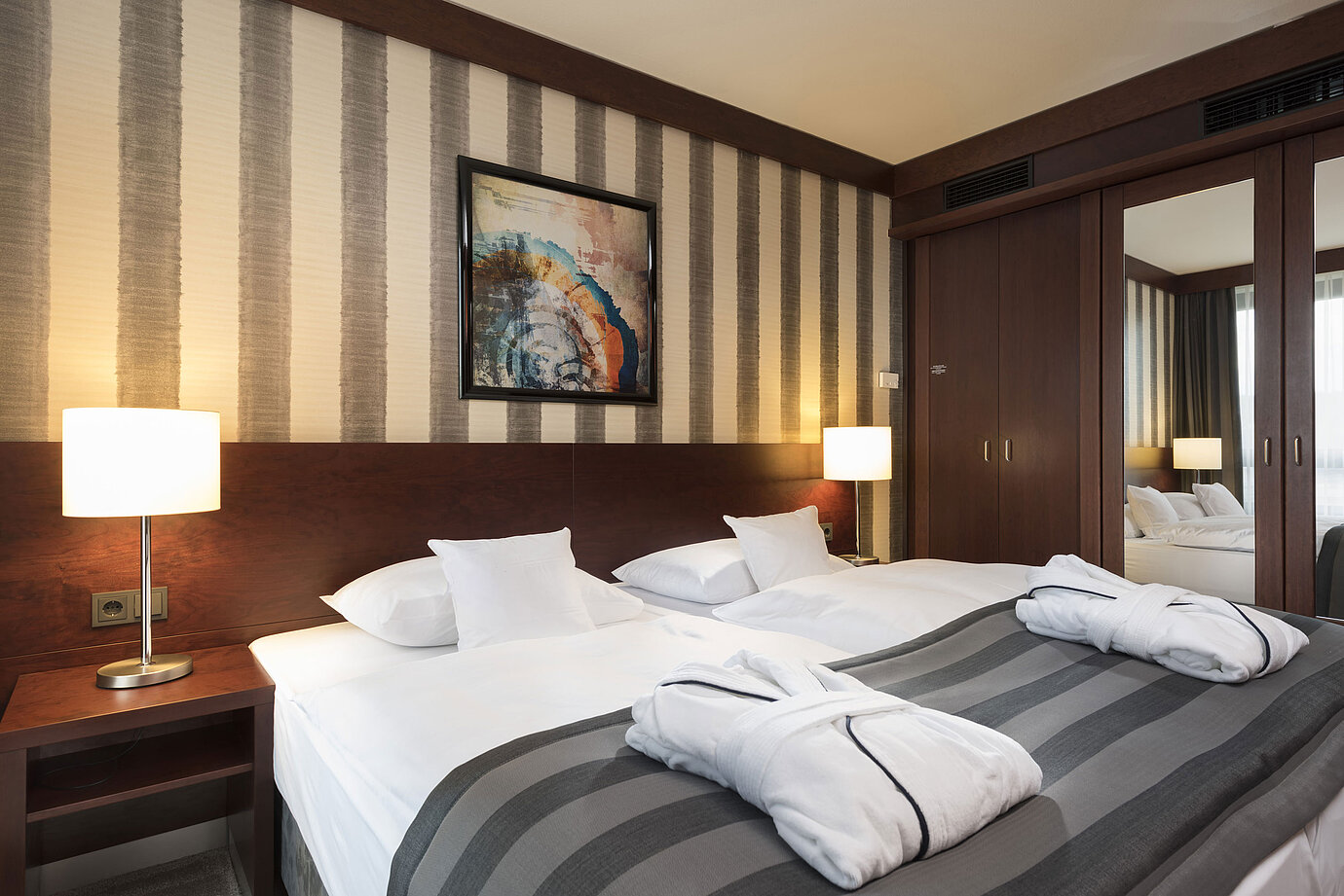 Habitación doble moderna con cama acogedora, albornoces e interior elegante en el Maritim Hotel Königswinter.
