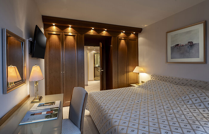 Suite présidentielle élégante de l'hôtel Maritim Kiel avec grand lit, bureau et décor en bois chaleureux.