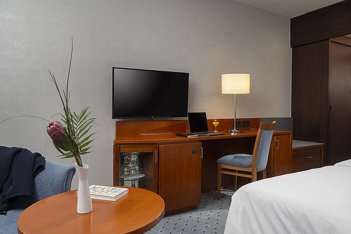 Área de trabajo en la habitación Classic del hotel Maritim Darmstadt con escritorio, TV y mobiliario moderno.